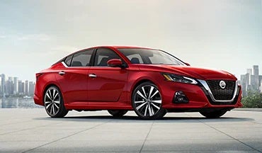 2023 Nissan Altima in red with city in background illustrating last year's 2022 model in Gates Nissan of Richmond in Richmond KY